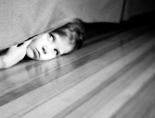 niño debajo de la cama